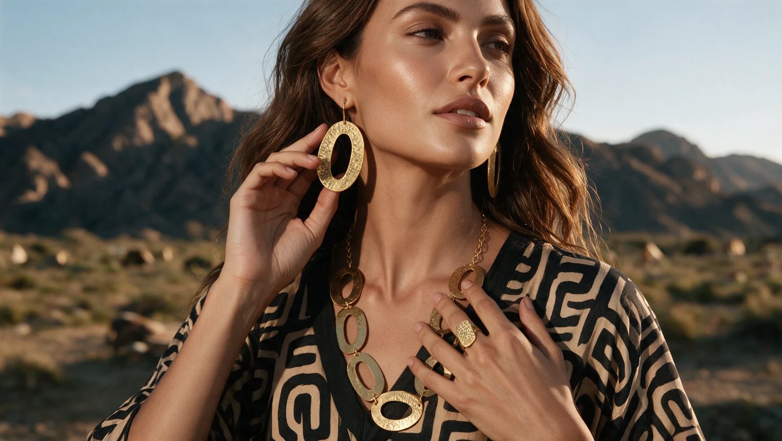 After: model wearing the gold oval necklace, earrings and ring in the desert