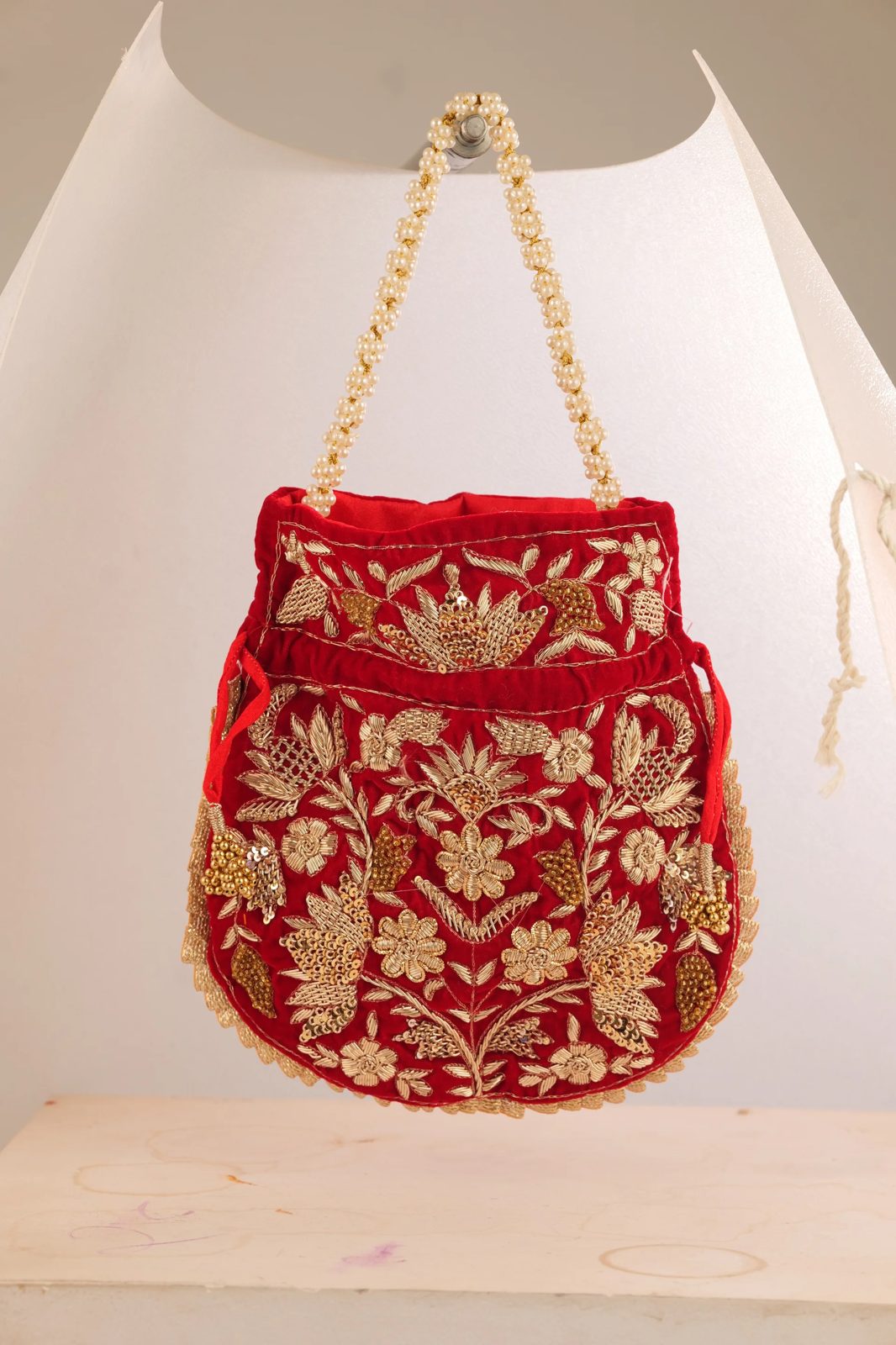 Before: red embroidered potli on a white backdrop